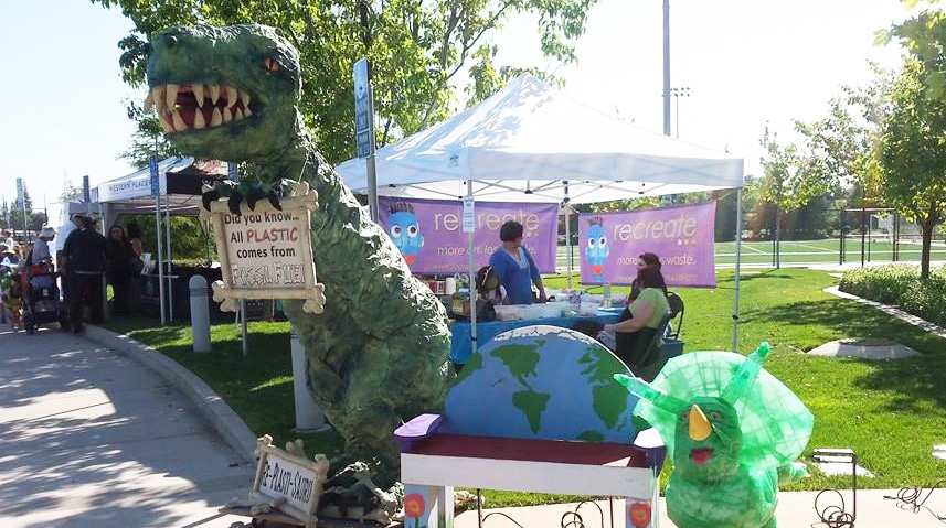A dinosaur holding a sign on earth day.